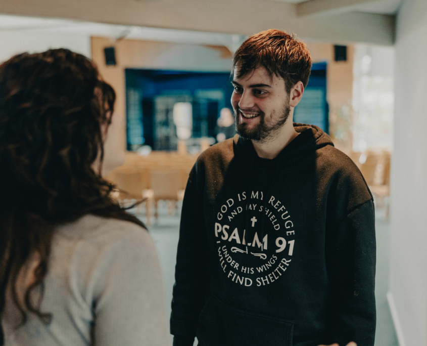 A student of the European Theological Seminary is smiling to another Student of the European Theological Seminary.