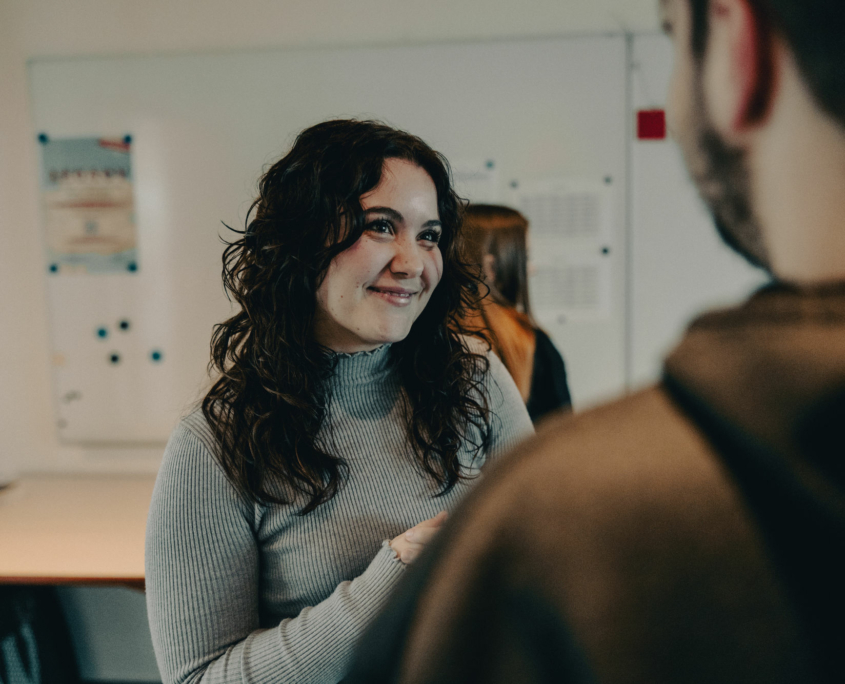 A female student of the European Theological Seminary is smiling to a fellow student